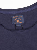 Close-up of the Sagi Nuovo T-shirt in Dark Navy by Blue de Gênes, a wardrobe staple with an inside collar label reading Perpetuo Merino and Large in orange text. A loop hangs below the label, as this premium cotton piece is elegantly displayed on a white background.