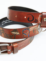 The Da Vinci Belt 4 cm - Brown by Blue de Gênes is made from premium leather, featuring crescent moon and abstract designs. It includes a silver buckle, a cross detail, and cursive handwriting inside that echoes Leonardo Da Vincis genius.
