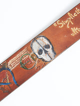 Check out the close-up of the Da Vinci Belt 4 cm in brown by Blue de Gênes, featuring a premium leather accessory with embossed artwork inspired by Leonardo Da Vinci. It includes a skull, abstract shapes, and handwritten text in rustic style with colors like white, blue, and red.