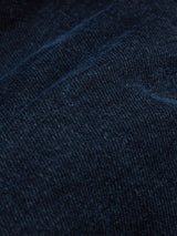 Close-up of Blue de Gênes Vinci 3325 Black Jeans in blue-black denim, highlighting its textured weave. Expertly crafted in Italy, this fabric has subtle color variations and a slightly worn look, enhancing its natural appearance and comfort stretch.