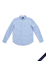 The Sandro Oxford Shirt by Blue de Gênes, in light blue, is crafted from organic cotton. It has long sleeves, a front chest pocket, and a button-down design. Laid flat on a white background, it features a small label in the bottom right corner reading The Classics.