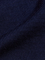 Close-up of a folded navy blue knitted fabric from Blue de Gênes, crafted from luxurious Merino wool, showcasing the texture and stitch pattern reminiscent of a Tributo Cycling Jersey.