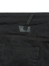 Close-up of slim-fit Repi Stay Black Jeans by Blue de Gênes, showcasing belt loops, pockets, and intricate stitching. The comfort stretch black denim features a textured look with visible seams and a patch near the top of the pocket.