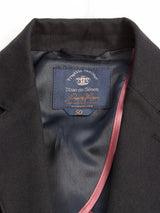 Close-up of a black Leopardi Carbonio Blazer from Blue de Gênes, crafted from Italian brushed cotton with size 50 and decorative buffalo horn buttons. A red lining accentuates the tailored design, while a visible label enhances its elegance.