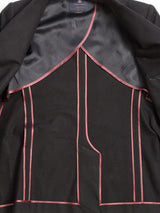 The image displays the interior of the Leopardi Carbonio Blazer - Black by Blue de Gênes, crafted from Italian brushed cotton with pink piping along seams and edges. The dark lining highlights meticulous stitching and features a label at the top center.