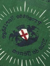 The Green Bandana from Blue de Gênes boasts a cotton fabric with two griffins holding a shield with a red cross. Progetto Heritage and Blue de Gênes are featured amidst white rays. This bold design is perfect for stylish scarves or unique attire, making a fashionable statement.