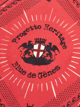 The Bandana - Red from Blue de Gênes features a central emblem with winged lions, a shield with a cross, and Progetto Heritage elegantly displayed. Decorative patterns enhance its timeless appeal.
