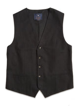 The Canna Carbonio Gillet - Black by Blue de Gênes is a black, sleeveless dress vest made from Italian brushed cotton. It features a V-neckline, five buffalo horn buttons, two front pockets, an adjustable back strap for fit, and a blue label inside the collar against a plain white background.