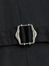 Close-up of the Canna Carbonio Gillet - Black by Blue de Gênes shows a dark Italian brushed cotton fabric with a metallic adjuster buckle. The curved rectangular buckle sits on an adjustable strap, enhancing the fabrics fine texture.