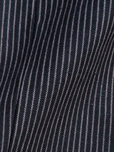 Close-up of a dark fabric with thin vertical white pinstripes, reminiscent of a classic Canna Pallone Gillet by Blue de Gênes. The slightly wrinkled texture adds depth and detail to the smooth cotton linen pattern.