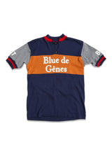 The Tributo Cycling Jersey - Navy by Blue de Gênes features a blue body with an orange chest stripe and gray sleeves with red and blue trim. The right sleeve proudly displays the number 17, making it a standout piece for cycling enthusiasts.