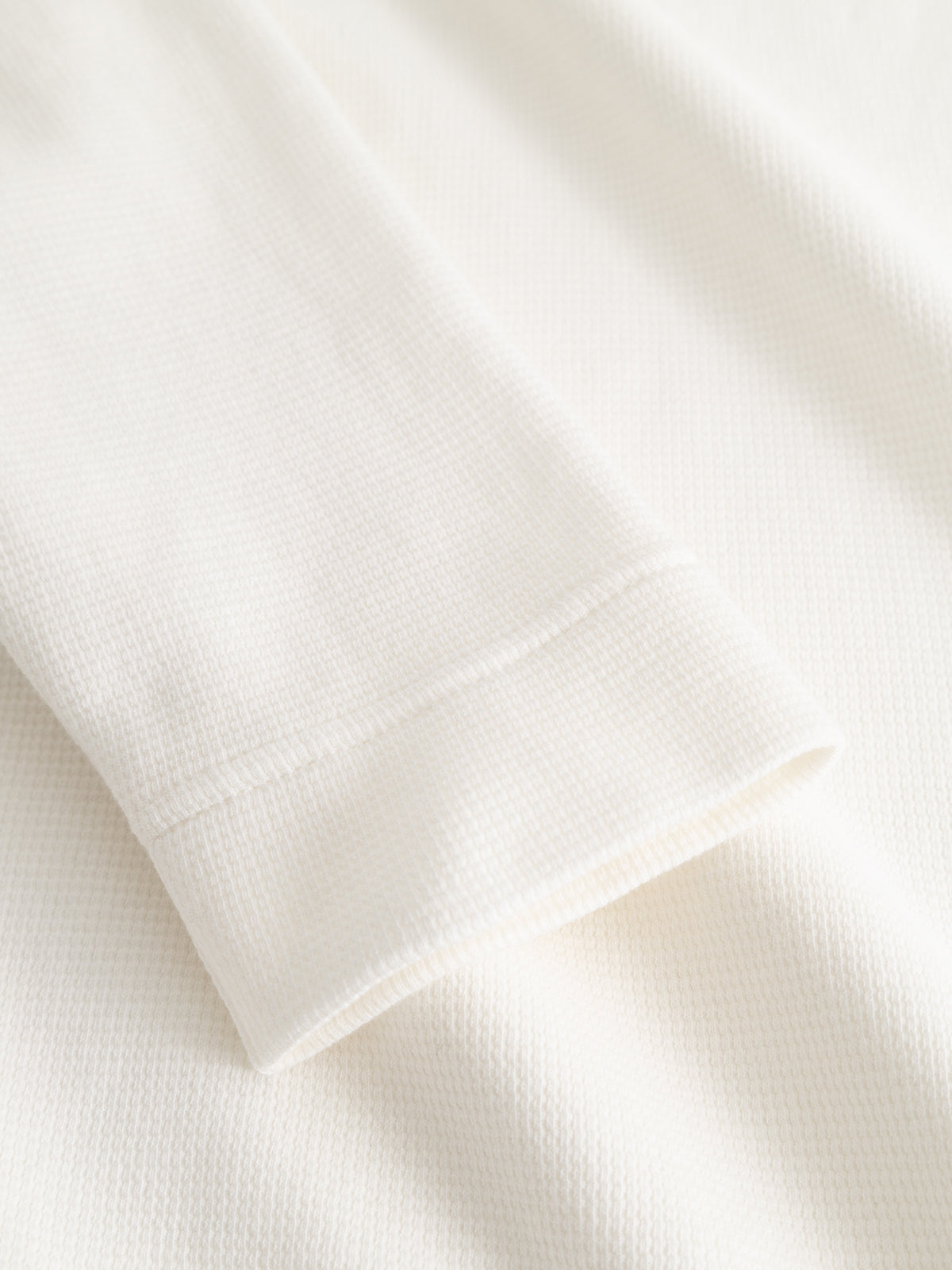 A close-up of a folded long-sleeve cuff on the Blue de Gênes BGgreg L/S Grandad shirt in white highlights the soft, subtly textured cotton poplin material.