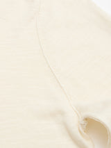 Close-up of the BGmonty Knit in Chalk by Blue de Gênes, showing a seam and part of an armhole in off-white cotton linen blend fabric with a soft, slightly textured look.