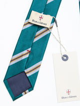 The BGponsy Tie - Green by Blue de Gênes is a teal striped silk tie with white, blue, and gold diagonal lines. It features a white tag attached with string and is displayed on a white background—an elegant accessory that effortlessly complements both formal and smart-casual outfits.