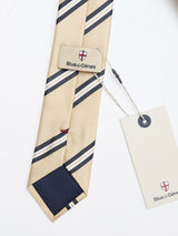 The BGponsy Tie - Pale Khaki by Blue de Gênes features khaki stripes with navy and white accents, a branded label, and a cream tag attached with string, elegantly displayed on a white background.