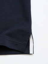 Close-up of the hem of the BGclubhouse Rugby Sweatshirt in navy by Blue de Gênes, crafted from soft cotton jersey and featuring a white fabric detail at the side vent, set against a light background—a refined piece from the Clubhouse Champs Collection.