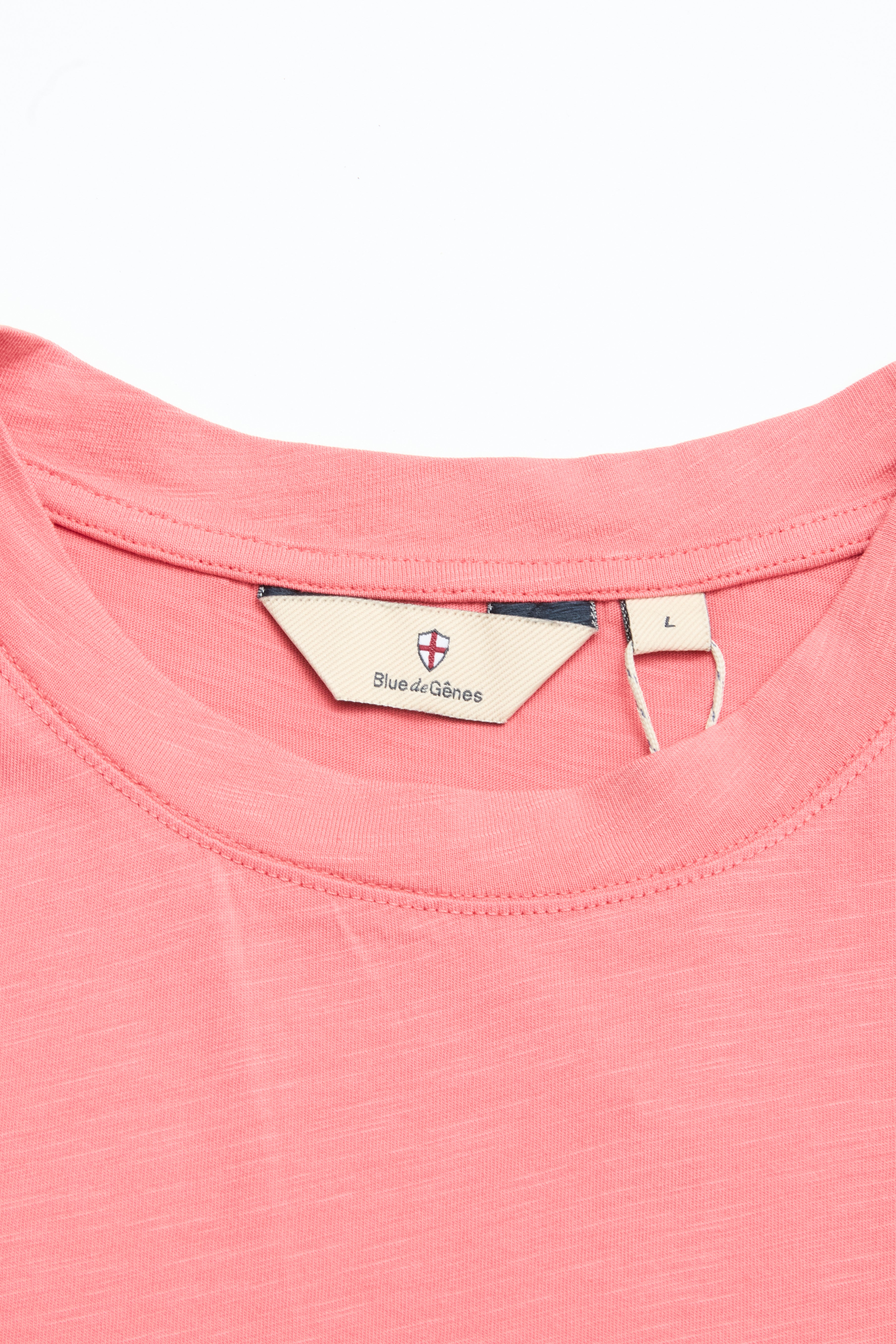 Close-up of a coral BGoscar T-Shirt collar with a beige Blue de Gênes label and L size tag. This regular fit, 100% cotton shirt is laid flat on a white background.