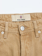 Close-up of tan BGgiacomo Color Jeans - Tanin by Blue de Gênes, highlighting the rigid denim waistband, belt loops, silver button, and an inner label featuring a red cross shield and the Blue de Gênes logo. These jeans offer a relaxed loose fit for easy style and comfort.