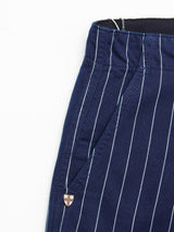 Close-up of a BGpalco Toll Pants - Navy Stripe pant leg by Blue de Gênes, featuring white vertical pinstripes and a pocket adorned with a small metal embellishment at the seam—crafted from premium striped cotton in the brand’s signature workwear-inspired style.