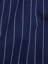 Close-up of the BGkendrick Toll Jacket - Navy Stripe by Blue de Gênes, featuring dark blue cotton fabric with evenly spaced, thin white vertical pinstripes.