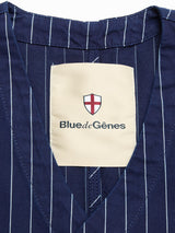 Close-up of the Blue de Gênes BGlumen Toll Gilet in navy stripe, featuring worker-inspired details and a beige label with a red and white shield plus the brand's signature text.