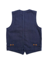The BGlumen Toll Gilet by Blue de Gênes is a navy stripe vest inspired by the brand’s signature aesthetic, shown from the back with vertical white pinstripes, two buttoned side adjuster straps, and a pointed bottom hem.