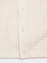 Close-up of the BGbilly S/S Cardigan in Chalk by Blue de Gênes, a cream-colored vintage knit featuring four buttons and a textured openwork pattern. Fabric and button details are clearly visible.