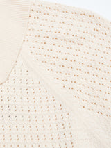 Close-up of the BGbilly S/S Cardigan in Chalk by Blue de Gênes, an off-white textured knit featuring a ribbed collar and a pattern of small, evenly spaced holes reminiscent of vintage cardigans.