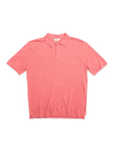 The BGwally Diamond Polo - Coral by Blue de Gênes is a short-sleeve polo shirt in light red, crafted from a cotton-linen blend with a diamond-knit pattern on the front, featuring three buttons at the collar and a straight hem.