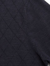 Close-up of the BGwally Diamond Polo in Dark Navy by Blue de Gênes, featuring a dark cotton linen blend fabric with a diamond quilted pattern and visible stitching along the seam, highlighting the texture and detail.