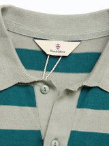 Close-up of the BGwally Stripe Polo - Shadow Green by Blue de Gênes, a green and light gray striped polo shirt made from premium cotton linen knit, detailed with corozo buttons and a signature Blue de Gênes label inside the collar.