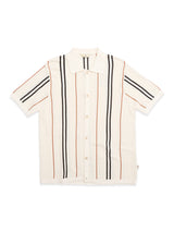 The BGwalter S/S Cardigan - Chalk by Blue de Gênes is a cream-colored, short-sleeve button-up shirt with a collar, featuring vertical black and brown stripes. Crafted from 100% cotton and inspired by the relaxed feel of a short sleeve knit cardigan, this piece is laid flat on a white background.