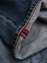 A close-up of the cuff of blue denim jeans showcases the selvedge edge with red stitching detail and contrasting yellow thread on the hem—classic details found in Blue de Gênes BGmarco Rowan Jeans - Used, featuring signature 5-pocket denim styling.