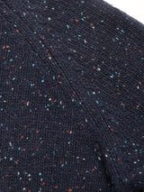 Close-up of the Honshu Crewneck Knit in Navy by Blue de Gênes, featuring a soft, chunky knit texture with small multicolored flecks of red, white, and blue yarn throughout. The slightly fuzzy sweater showcases diagonal seam lines for added detail.