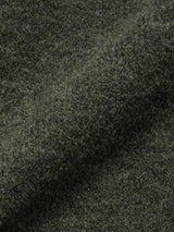 Close-up of the Malakka Polo Knit - Army by Blue de Gênes, highlighting its textured dark green wool blend fabric with a soft, fuzzy surface, natural fibers, gentle folds, and subtle shadows.