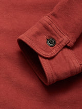 A close-up of the Blue de Gênes Nagano Overshirt - Henna cuff, featuring a black button and detailed fabric texture and stitching.
