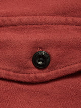 Close-up of the Nagano Overshirt - Henna by Blue de Gênes, highlighting its reddish-brown wool fabric pocket and a black button engraved with the brand’s name.