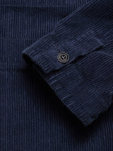 Close-up of the Masami Cord Blazer in Navy by Blue de Gênes, highlighting the sleeve’s black button and signature vertical ribbed corduroy texture, inspired by classic workwear.