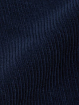 Close-up of the dark navy 7-wale corduroy fabric, as featured in the Blue de Gênes Etsu Cord Chino – Navy, highlighting its vertical ribbed texture and soft, velvety surface with subtle folds and shadows.