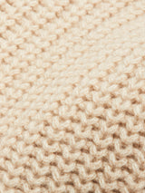 Close-up of beige wool knitted fabric, highlighting the texture and stitch details found in the Yomaha Halfzip Knit - Fungi sweater by Blue de Gênes.