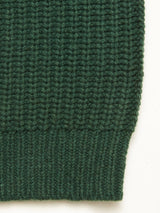 Close-up of the Blue de Gênes Yomaha Halfzip Knit in Scarab, highlighting its ribbed texture and detailing at the hem against a plain white background.
