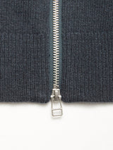 Close-up of the silver zipper partially unzipped on the Blue de Gênes Nuvali Polo Cardigan in Dark Slate, photographed against a white background.