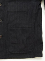Close-up of the front of a Blue de Gênes Vincenzo Solid Jacket - Dark Navy, featuring brown buttons and a large rectangular front pocket with visible stitching on textured Italian wool fabric.