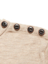 Close-up of the Toyama Knit L/S - Oat by Blue de Gênes, a beige Merino wool sweater crafted in Denmark with four dark brown shoulder-buttons sewn with tan thread.