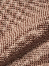 Close-up of textured, light brown knitted fabric with a ribbed pattern and a gentle diagonal fold, echoing the premium craftsmanship of the Blue de Gênes Porto Polo Knit - Fungi.