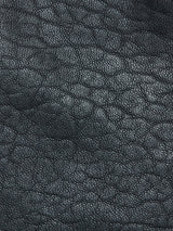 Close-up of dark gray, textured leather surface on the Blue de Gênes Saga Shearling Gilet – Scarab, crafted from premium German Merino sheepskin and showing natural grain patterns and fine creases.