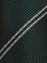 Close-up of the Nekutaki Tie #D - Green Stripe by Blue de Gênes, showcasing its textured black fabric with a grid pattern and two parallel reflective silver stripes running diagonally—an elegant detail reminiscent of classic tie craftsmanship, making it a sophisticated choice for men’s fashion.