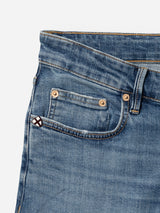 Close-up of Blue de Gênes BGvinci Girisha Used Jeans in blue comfort stretch denim, highlighting the front and coin pockets with a white and red stitched patch, visible stitching, and rivets against a light background.