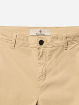 Close-up of the waistband and upper front of BGmenzo Vecchio Chino in Pale Khaki by Blue de Gênes, featuring comfort stretch, belt loops, a black button, and the Blue de Gênes label above the button.