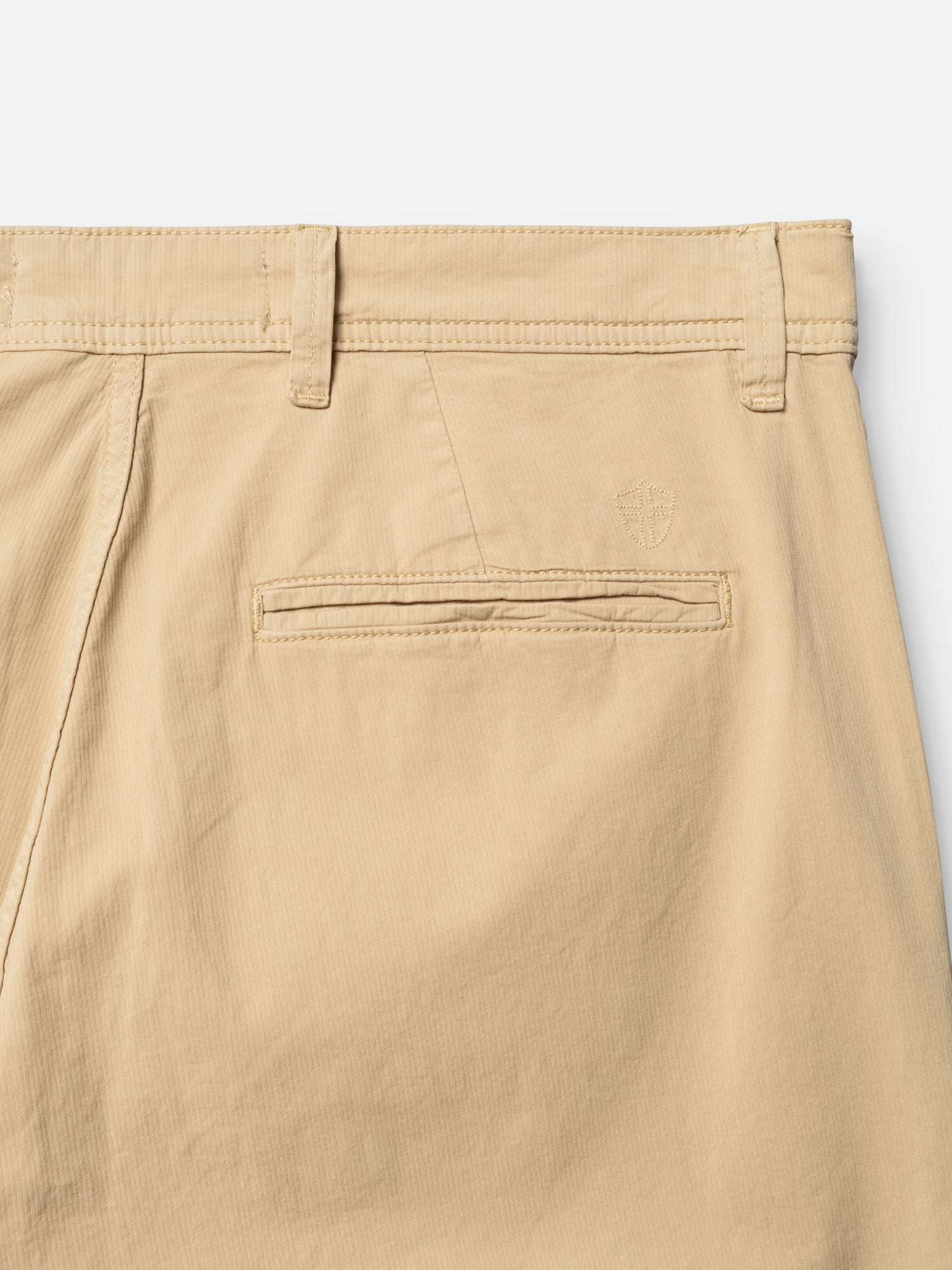 Close-up of the BGmenzo Vecchio Chino in Pale Khaki by Blue de Gênes, featuring a single welt pocket, belt loops, and a subtle embroidered logo above the pocket on lightweight fabric.